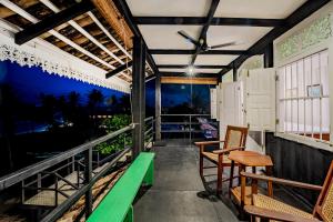 a porch with two chairs and a table on a balcony at Secret Beach Ahangama in Ahangama