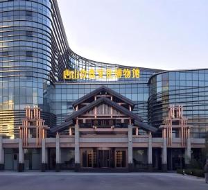 un grand bâtiment avec une enseigne au sommet dans l'établissement GreenTree Inn Tangshan Nanhu International Exhibition Center, à Tangshan