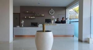 zwei Personen stehen an der Rezeption in einer Lobby in der Unterkunft Hart Hotel Premium Rapatmaja in Tjakranegara + 35 Fotos
