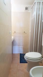 a bathroom with a toilet and a sink at La Baia Apartments in Putzu Idu