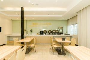 un restaurant avec des tables en bois et un comptoir dans l'établissement City Comfort Inn Changsha Window of the World Zhongmao City, à Changsha
