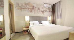 un grand lit blanc dans une chambre d'hôtel dans l'établissement City Comfort Inn Changsha Window of the World Zhongmao City, à Changsha