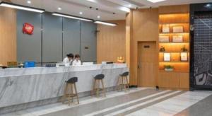 un hall avec des personnes assises à un comptoir dans l'établissement Thank Inn Hotel Guangdong Jiangmen Kaiping Donghui City, à Kaiping