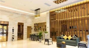 a lobby with a couch and a table and chairs at City Comfort Inn Tonglu Fuchun River Qiaolin Road in Tonglu