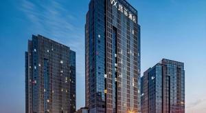 two tall skyscrapers in a city at dusk at VX Hotel Wuxi Xinwu District Executive Center Wanda Plaza in Wuxi
