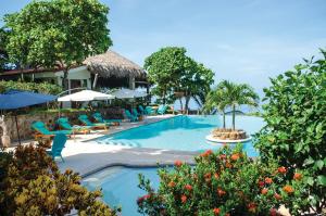 una piscina en un complejo con sillas y sombrillas en Paraiso Escondido Hotel Villas & Resort, en El Níspero