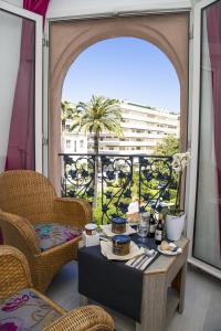 a room with a table and chairs and a balcony at Cristal Hôtel & Spa in Cannes