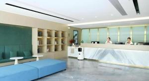 a room with a reception counter with two women in an office at Gya Hotel Wuxi Hubin Commercial Street Tai Lake Scenic Area in Wuxi
