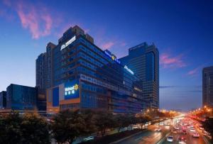 a tall building with cars on a city street at Gya Hotel Chengdu Global Center Jinchenghu Metro Station in Chengdu