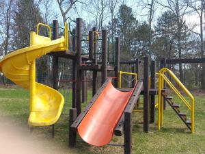 a group of playground equipment with yellow and orange slides at Countryside Inn in Kingston