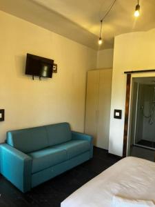 a living room with a blue couch and a bed at La Locanda della Mandria 1 in Venaria Reale