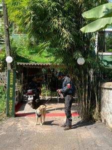a man walking a dog on a leash at GREEN NEST HOSTEL - Anjuna - North Goa in Arpora
