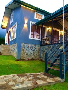 ein blaues Haus mit einer Treppe davor in der Unterkunft Tidenest Cottage in Nuwara Eliya