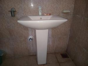 lavabo blanco en la esquina de un baño en BG Guest House Jaffna, en Tirunelveli East 8 fotos más