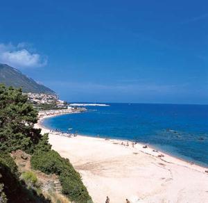a beach with people on the sand and the ocean at Seliche in Cala Gonone