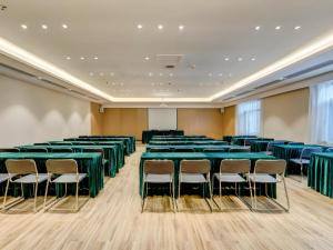 a conference room with green tables and chairs at City Comfort Inn Tangshan Railway Station Lunan District Government in Tangshan