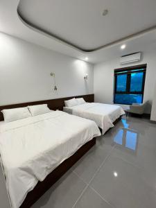 Un dormitorio con dos camas y una ventana en Tea hotel by Chiến Hảo, en Ha Giang