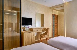 Una habitación de hotel con dos camas y un escritorio con televisión. en Cleo Patra Pyramids Tower Inn, en Banī Ghālib