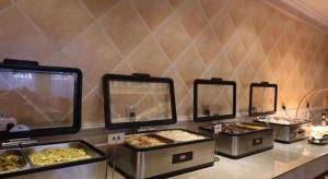 Un buffet con varias bandejas de comida en un mostrador. en Vienna Hotel Inner Mongolia Tongliao Development Zone, en Tongliao