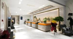 a lobby with a waiting area with a horse on the wall at Vienna Hotel Jinan Beiyuan Street Red Star Macalline in Jinan