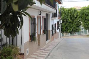 an empty street next to a white building at Hostal Caminito del Rey in Alora