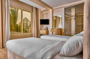 um quarto de hotel com duas camas e uma janela em Cleo Patra Pyramids Tower Inn em Banī Ghālib