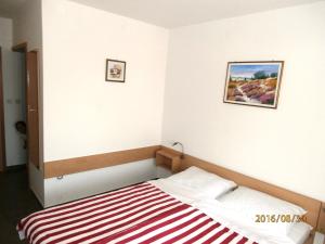 德拉格Apartments Meni的一间卧室配有一张带红白条纹毯子的床