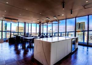 Großes Zimmer mit Tischen, Stühlen und großen Fenstern in der Unterkunft AltitudeOne - Downtown Montreal Penthouse & Condo - Pool Spa Parking in Montreal + 13 Fotos