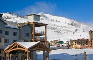 un gran edificio con una torre de reloj en la nieve en Silverado Lodge by Park City - Canyons Village, en Park City