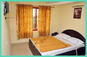 Un dormitorio con una cama y una ventana con cortinas. en HOTEL Shiv P Near Shri Mahakaleshwar Jyotirlinga Temple - Railway Station Ujjain - Fully Air conditioned - Free Wifi and Parking Facilities, en Ujjain 1 foto más
