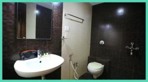 Un baño con lavabo blanco y inodoro. en HOTEL Shiv P Near Shri Mahakaleshwar Jyotirlinga Temple - Railway Station Ujjain - Fully Air conditioned - Free Wifi and Parking Facilities, en Ujjain