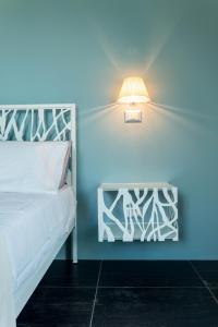 RutinoにあるSuite16のベッドルーム1室(ベッド1台付)、壁にランプが備わります。