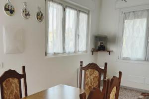 Un comedor con una mesa y dos ventanas. en Rustico da Pina con angolo cottura, en Castions 7 fotos más