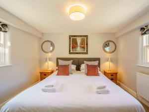 a bedroom with a large white bed with two mirrors at 2 Bed in Sedbergh 89266 in Milnthorpe