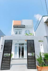 a white house with an open door at Nha Trong Pho - Green House in Buôn Ðũng