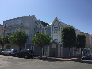 a large building with cars parked in front of it at Hôtel Calme Des Pins & Spa in Les Sables-d'Olonne