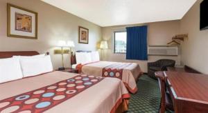 a hotel room with two beds and a desk at Quality Inn & Suites in Bridgeton
