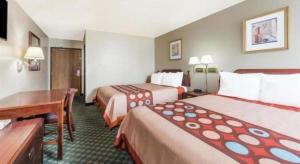 a hotel room with two beds and a desk at Quality Inn & Suites in Bridgeton