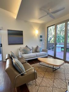 a living room with a couch and a table at Allure Stradbroke Resort in Point Lookout +91 photos