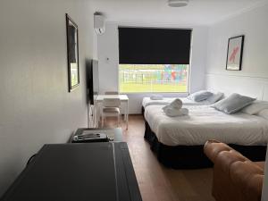 a hotel room with two beds and a table at Waterview Motel Sussex Inlet in Sussex inlet