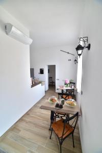 una sala da pranzo con tavoli, sedie e parete bianca di Suite Varigotti a Varigotti