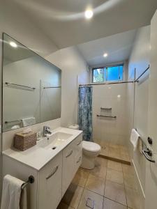 a bathroom with a sink and a toilet and a mirror at Allure Stradbroke Resort in Point Lookout