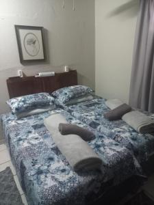 a bed with two pillows and towels on it at Wildepeer in Nelspruit
