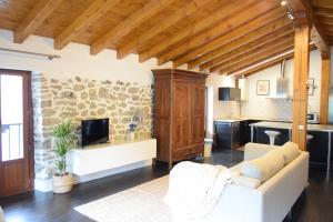 a living room with a couch and a stone wall at Batxillerenea in Doneztebe