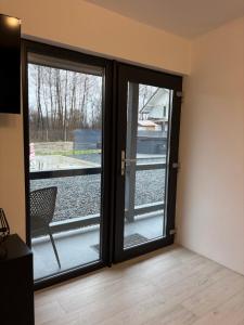 a room with two sliding glass doors with a chair at Secret Forest Avrig By Erwin in Avrig +10 photos