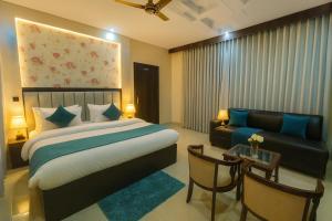 a hotel room with a bed and a couch at Hotel Ramawati, A Luxury Hotel & Resort, Haridwar in Haridwār +28 photos