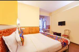 科代卡纳尔JS Heritage的一间卧室，墙上有一张床和一台电视