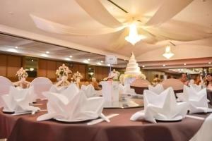 une salle de banquet avec des chaises blanches et un gâteau de mariage dans l'établissement K.P. Grand Hotel Chanthaburi, à Chanthaburi 70 autres photos