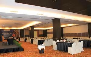 Un salón de banquetes con mesas y sillas blancas. en Grand Surya Hotel Kediri, en Kediri 158 fotos más