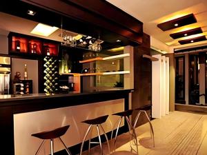 - un bar avec tabourets dans une pièce avec bouteilles de vin dans l'établissement Savali Hotel, à Kampungdurian